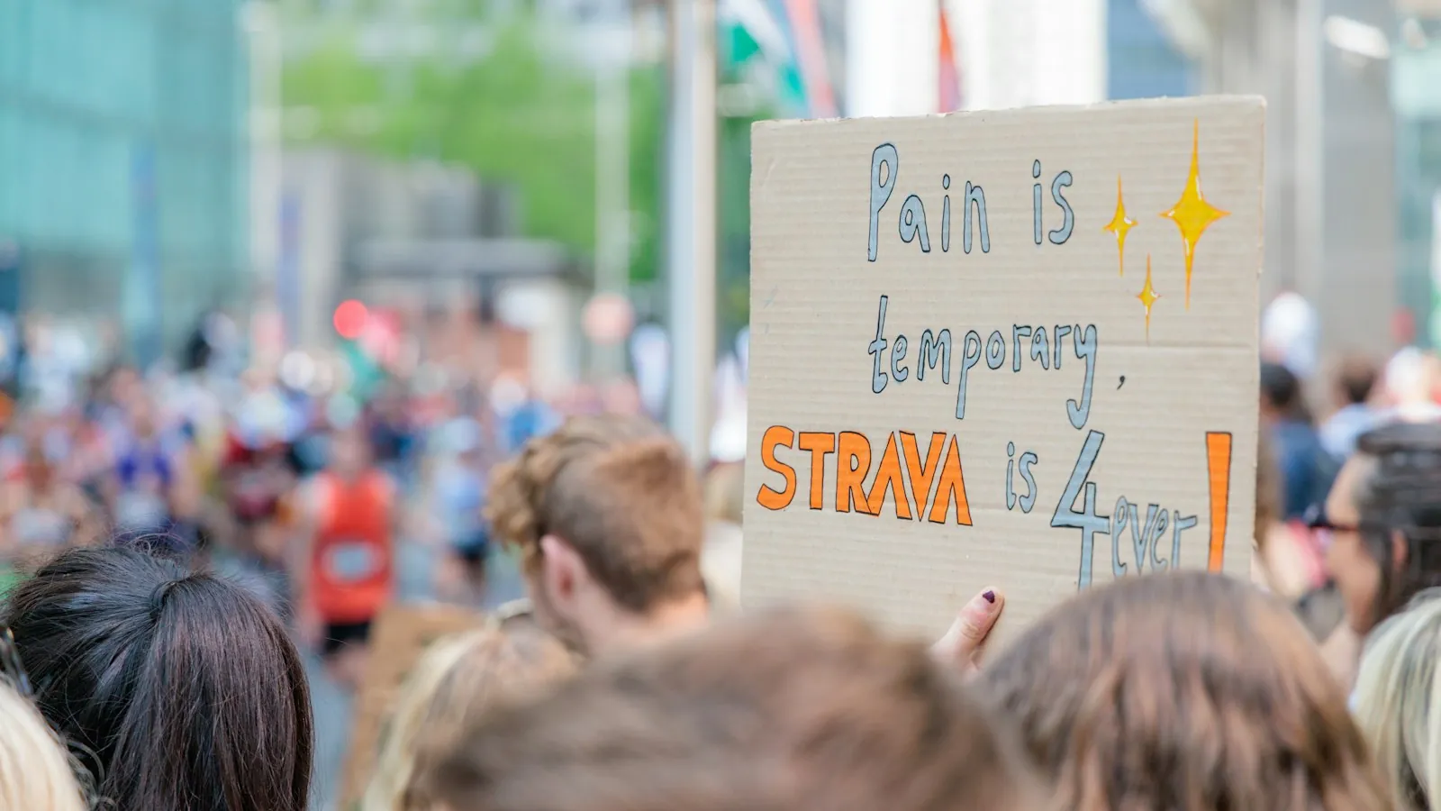 Szurkoló egy kartontáblával a mezőny mellett egy városi maratonon