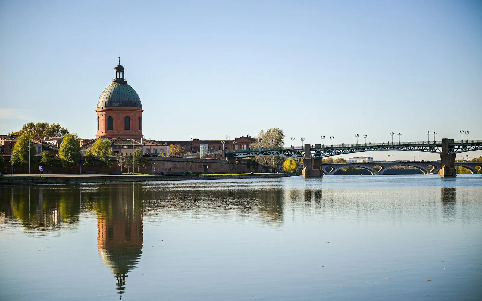 The dome of La Grave and the Pont Saint-Pierre reflected in the calm Garonne in Toulouse